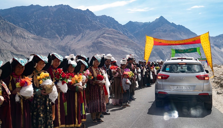 Los lugareños vestidos con trajes tradicionales bordean el camino para dar la bienvenida a Su Santidad el Dalái Lama en el valle de Nubra en Ladakh, J&K, India, el 12 de julio de 2018. Foto de Tenzin Choejor