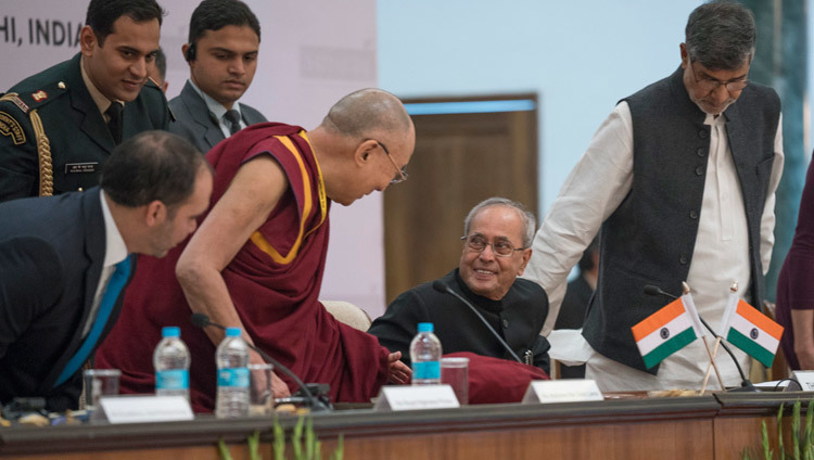 Su Santidad el Dalái Lama hablando con el Presidente de la India Pranab Mukherjee mientras toma asiento al comienzo de la Cumbre de Laureados y Dirigentes en favor de la infancia en Nueva Delhi, India, el 10 de diciembre de 2016. Foto/Tenzin Choejor/OHHDL