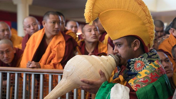 Un monje tocando un cuerno tradicional acompaña a Su Santidad el Dalái Lama al trono de enseñanzas en el patio del Tsuglagkhang en Dharamsala, HP, India, el 12 de marzo de 2017. Foto de Tenzin Choejor/OHHDL