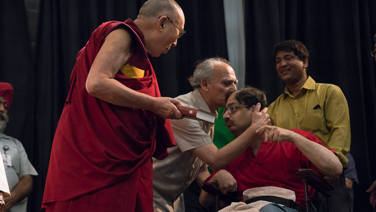 Arun Shourie besando a su hijo Aditya, quien había entregado a Su Santidad el Dalái Lama un ejemplar de «Dos Santos» para conmemorar el lanzamiento del libro en el Centro Internacional Indio de Nueva Delhi, India, el 25 de mayo de 2017. Foto de Tenzin Choejor/OHHDL