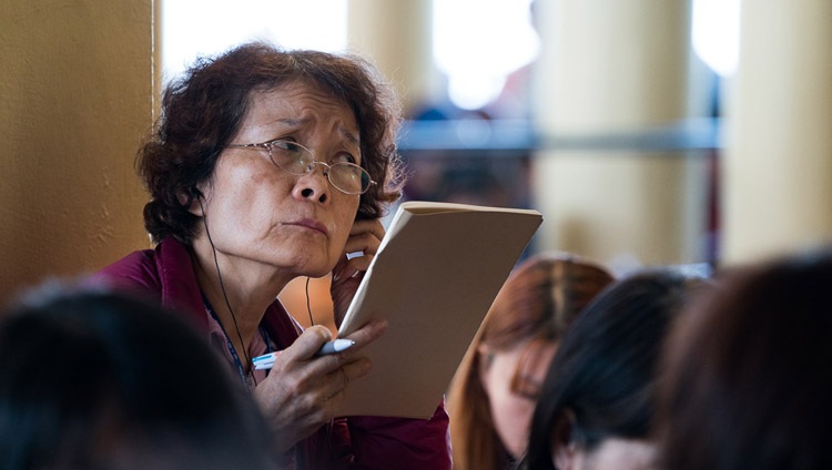 Una persona del público escuchando la traducción en FM de Su Santidad el Dalái Lama en el tercer día de sus enseñanzas, solicitadas por los budistas taiwaneses, en el Tsuglagkhang en Dharamsala, HP, India el 5 de octubre de 2017. Foto de Tenzin Choejor
