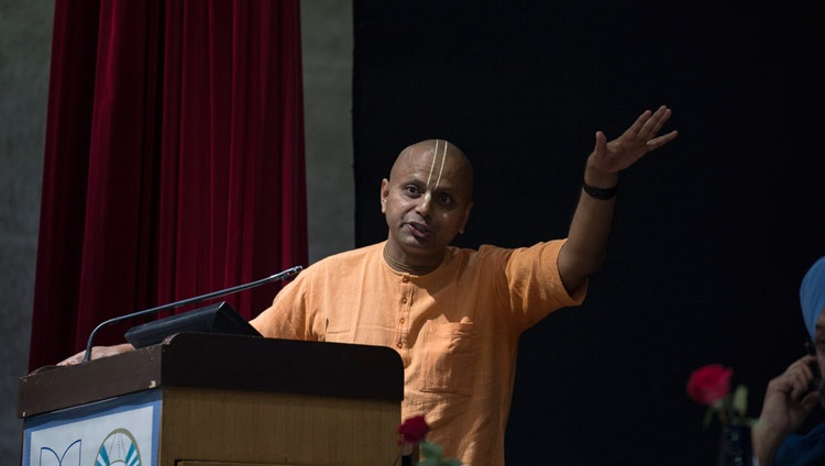 Shri Gaurgopal Das hablando en la conferencia interreligiosa en la Universidad Jawaharlal Nehru en Nueva Delhi, India el 28 de diciembre de 2017. Foto de Tenzin Choejor