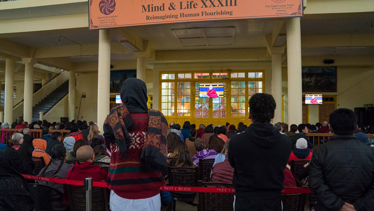 Miembros del público viendo a Su Santidad el Dalái Lama en la televisión en el patio del Templo Principal Tibetano en el cuarto día de la Conferencia de Mente y Vida en Dharamsala, HP, India el 15 de marzo de 2018. Foto de Tenzin Choejor