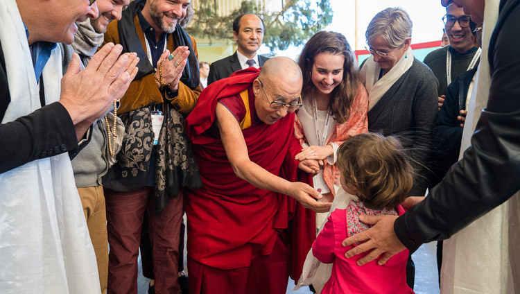 Su Santidad el Dalái Lama saluda con cariño a una joven que se dirige al Templo Principal Tibetano para participar en el último día de la Conferencia de Mente y Vida en Dharamsala, HP, India, el 16 de marzo de 2018. Foto de Tenzin Choejor