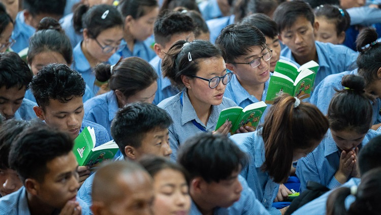 Jóvenes estudiantes siguen el texto que Su Santidad el Dalái Lama lee de la "Guía de la forma de vida del Bodhisattva" en el último día de sus enseñanzas para jóvenes estudiantes tibetanos en el Templo Principal Tibetano en Dharamsala, HP, India, el 8 de junio de 2018. Foto de Tenzin Choejor