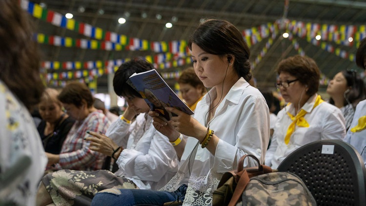 Miembros de la audiencia leyendo los textos junto con Su Santidad el Dalái Lama en el segundo día de sus tres días de enseñanza en Riga, Letonia, el 17 de junio de 2018. Foto de Tenzin Choejor