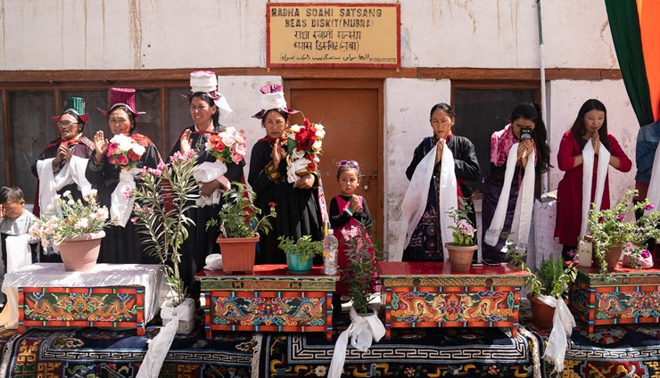 Algunos lugareños de pie junto a una mesa tallada con flores en macetas para dar la bienvenida a Su Santidad el Dalái Lama en el valle de Nubra en Ladakh, J&K, India, el 12 de julio de 2018. Foto de Tenzin Choejor