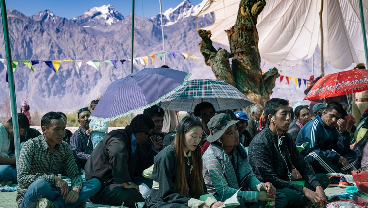 Las montañas se elevan desde el valle de Nubra en el fondo mientras los miembros de la audiencia escuchan las enseñanzas de Su Santidad el Dalái Lama en el Monasterio Samstanling en Sumur, valle de Nubra, Ladakh, J&K, India el 16 de julio de 2018. Foto de Tenzin Choejor