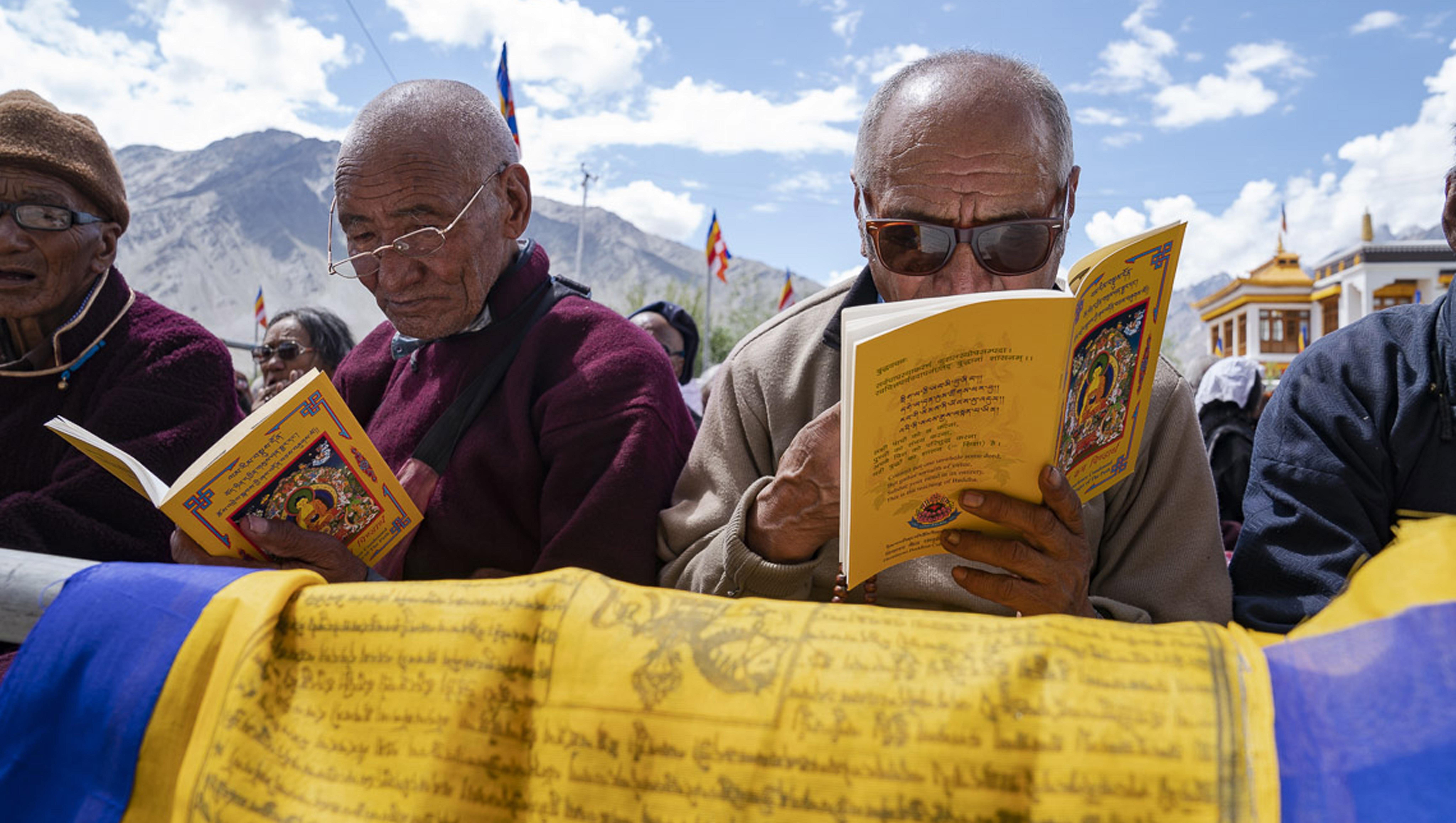  Miembros de la audiencia siguiendo el texto durante la enseñanza de Su Santidad el Dalái Lama en Padum, Zanskar, J&K, India el 22 de julio de 2018. Foto de Tenzin Choejor
