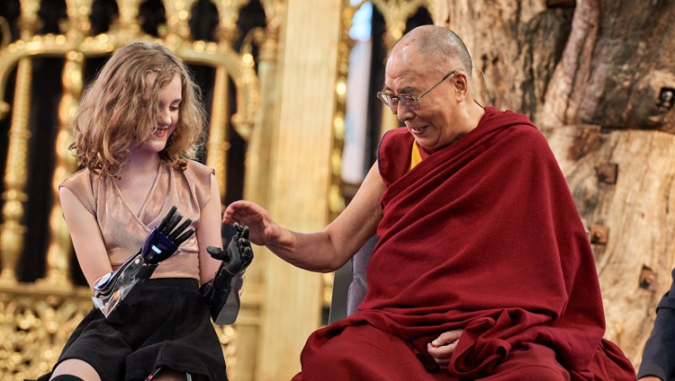 Su Santidad el Dalái Lama examinando las manos protésicas de Tilly Lockey durante el debate sobre «Robótica y telepresencia» en el Nieuwe Kerk de Amsterdam, Países Bajos, el 15 de septiembre de 2018. Foto de Olivier Adam