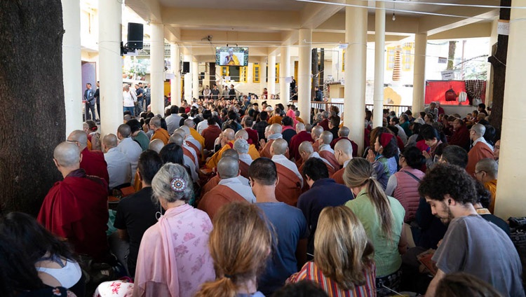 Miembros de la audiencia sentados fuera del Templo Principal Tibetano viendo a Su Santidad el Dalái Lama en las pantallas de televisión en el segundo día de enseñanzas en Dharamsala, HP, India, el 4 de octubre de 2018. Foto de Ven Tenzin Jamphel