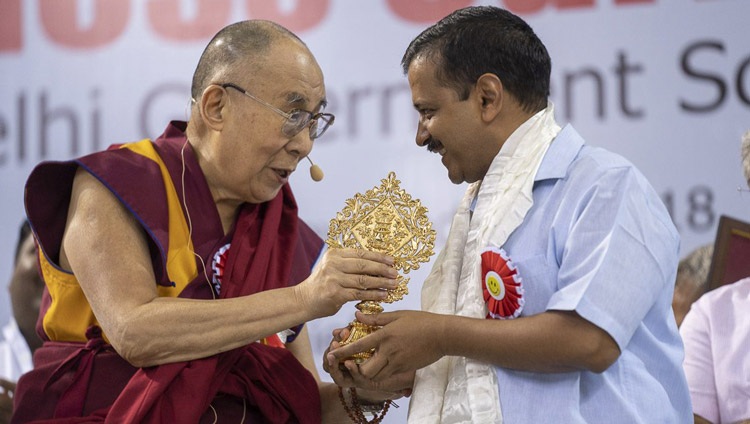 Su Santidad el Dalái Lama obsequió al Ministro Principal de Delhi, Arvind Kejriwal, con un emblema auspicioso al concluir la presentación del Programa de Felicidad en las escuelas públicas de Delhi en el Estadio Thyagraj de Nueva Delhi (India) el 2 de julio de 2018. Foto de Tenzin Choejor