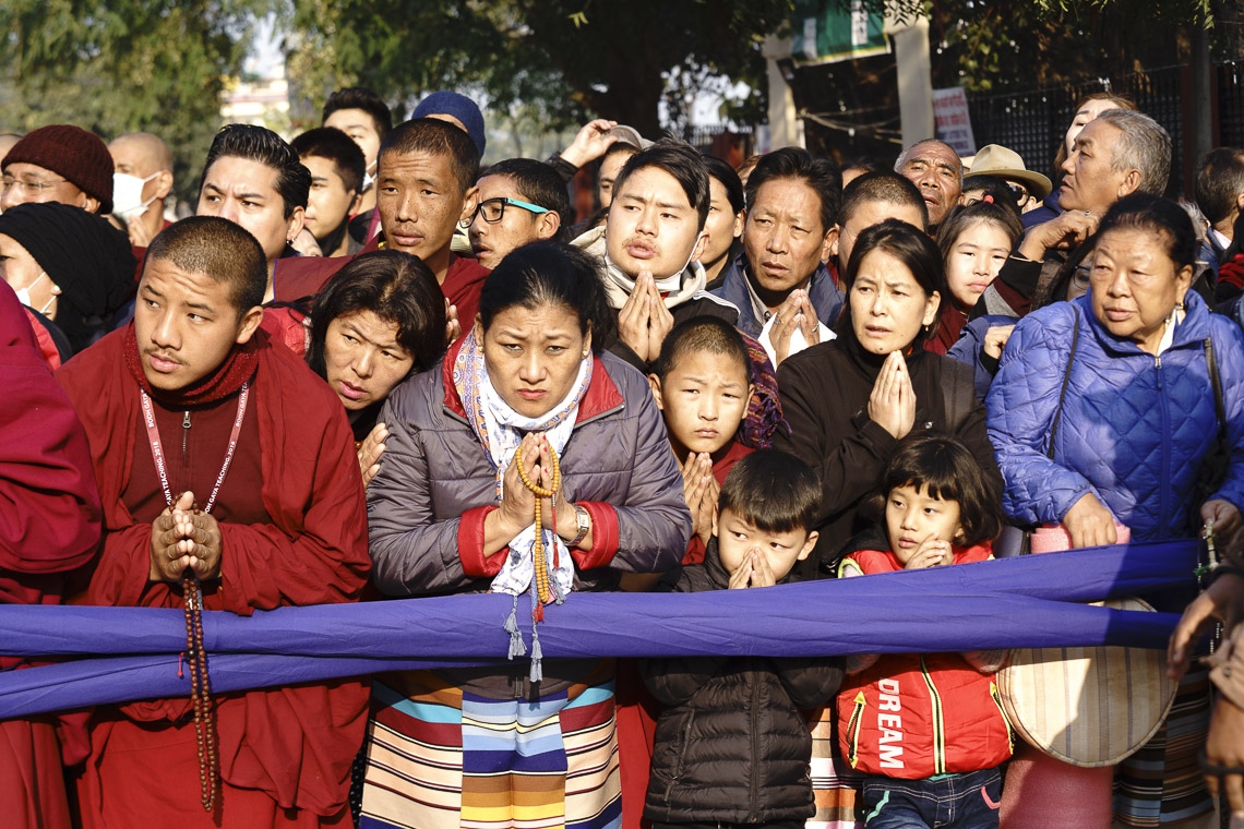 La gente se reunió a un lado del camino esperando para ver a Su Santidad el Dalái Lama mientras caminaba desde el Monasterio de Gaden Phelgyeling hasta el terreno de Kalachakra en el segundo día de sus enseñanzas en Bodhgaya, Bihar, India, el 25 de diciembre de 2018. Foto de Lobsang Tsering