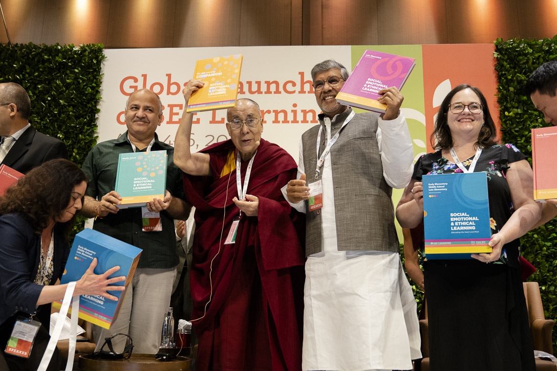 Su Santidad el Dalái Lama con el Viceministro Jefe de Delhi, Manish Sisodia, y el Premio Nobel de la Paz, Kailash Satyarthi, celebrando los libros de texto del plan de estudios SEE Learning en Nueva Delhi, India, el 5 de abril de 2019. Foto de Tenzin Choejor