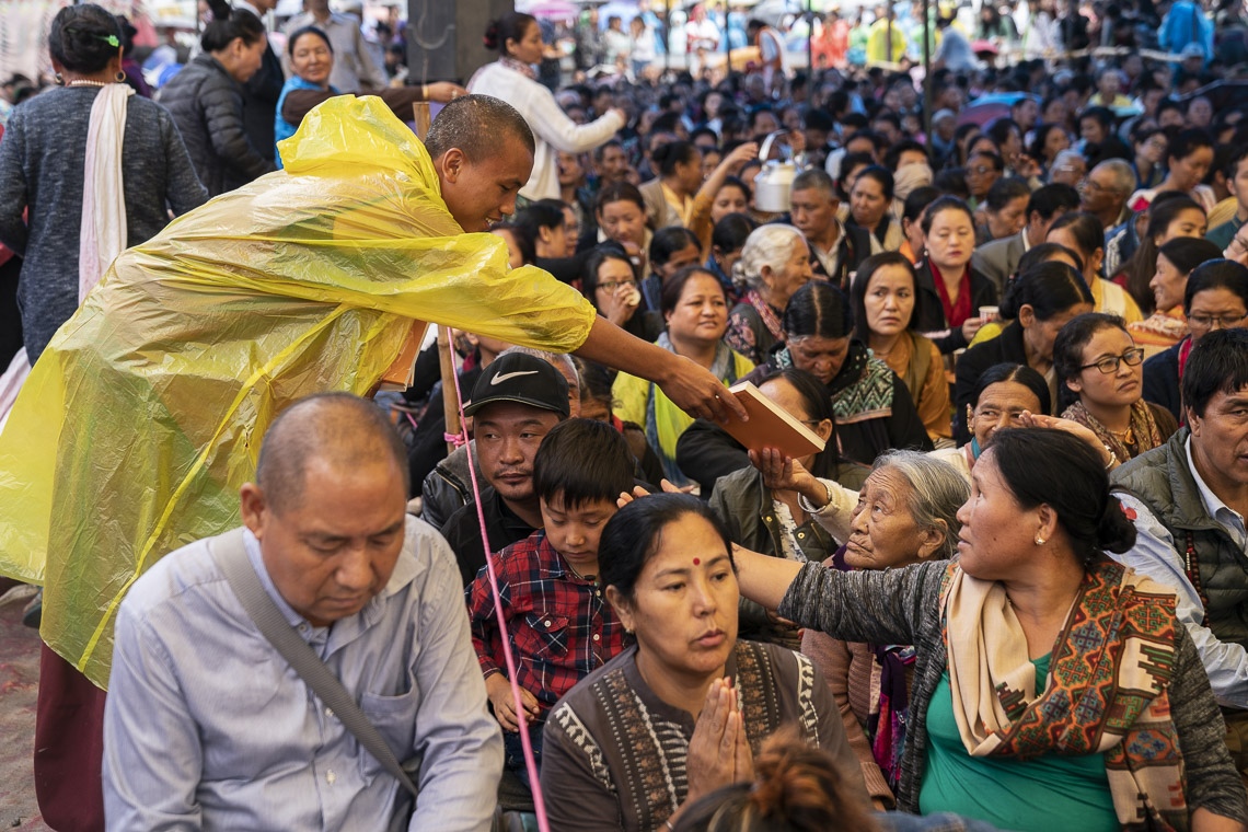 Voluntarios repartiendo libros a los miembros de la audiencia en el segundo día de las enseñanzas de Su Santidad el Dalái Lama en Manali, HP, India, el 14 de agosto de 2019. Foto de Tenzin Choejor