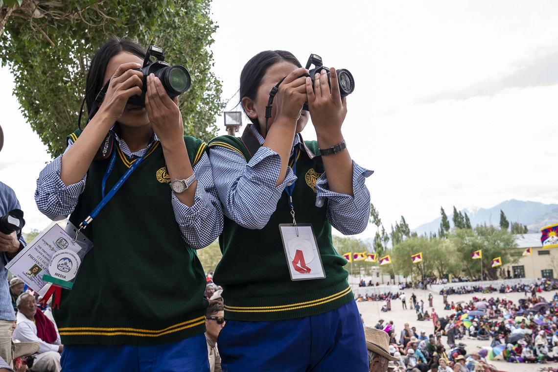 Unas integrantes del Club de Fotografía del TCV tomando fotos durante la charla de Su Santidad el Dalái Lama en la Escuela Choglamsar de la Aldea de Niños Tibetanos en Leh, Ladakh, J&K, India el 1 de agosto de 2018. Foto de Tenzin Choejor