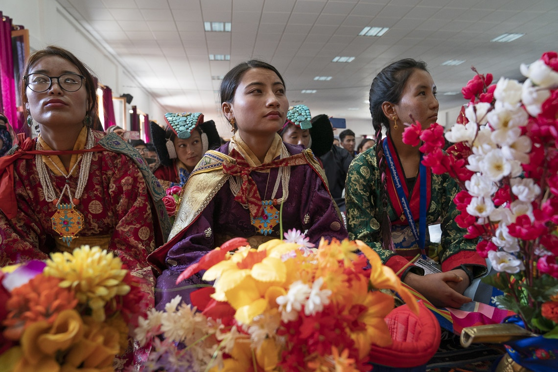 Algunas de los más de 1.500 estudiantes, muchos de ellos vestidos con trajes tradicionales, observando cómo Su Santidad el Dalái Lama llega al escenario del Eliezer Joldan Memorial College en Leh, Ladakh, J&K, India, el 2 de agosto de 2018. Foto de Tenzin Choejor
